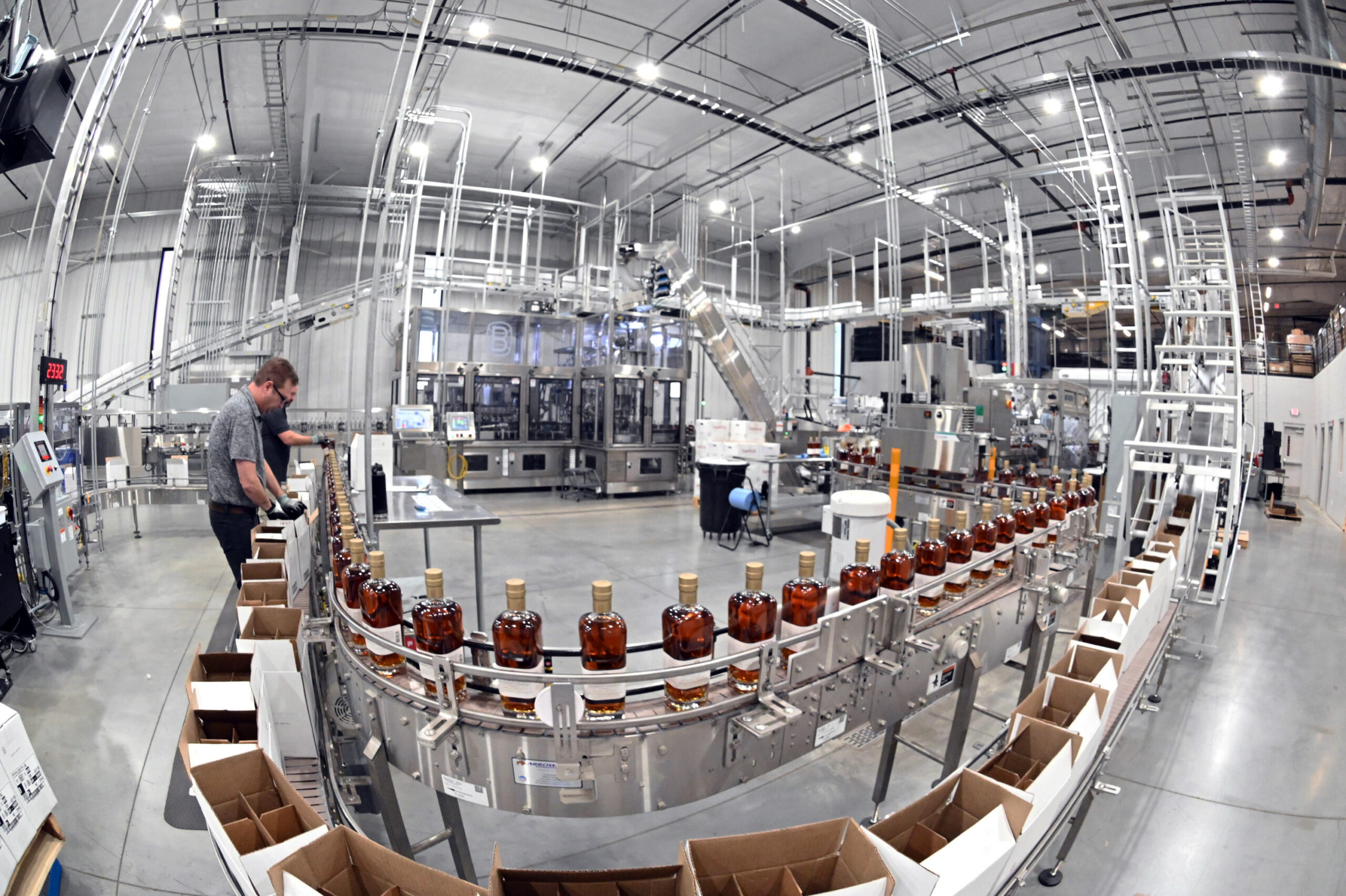 Bourbon bottles on conveyor belt for contract distilling and contract bottling.